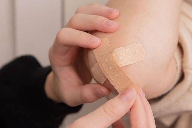 A man putting the adhesive tape on the knee