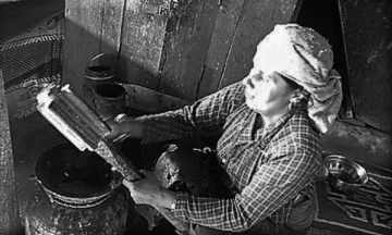 A woman taking out butter from Madani after butter churning