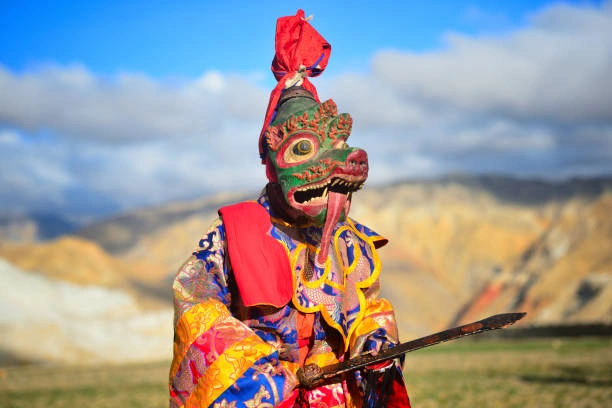 Masked performer carrying ceremonial sword at Tiji Festival