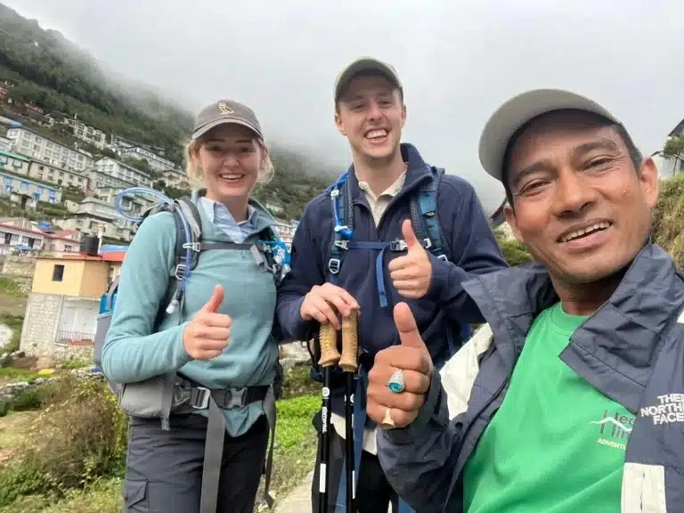Two trekker and guide pose for a selfie during Everest Base Camp Trek in Autumn